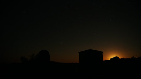 Moon rising behind observatory dome and control building at nightの写真素材