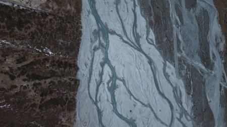 Aerial view of glacial river patterns on rocky terrain with textures