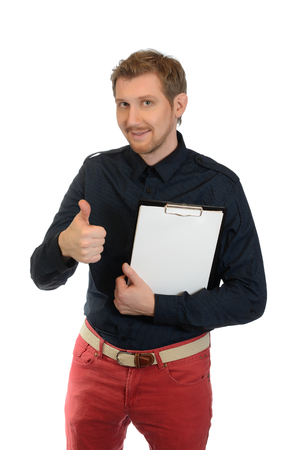 An office worker with red hair shows a thumbs up and in the other hand holds a white folderの写真素材
