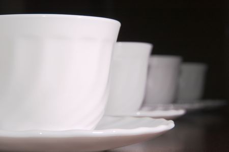 Some white tea cups on a black backgroundの写真素材