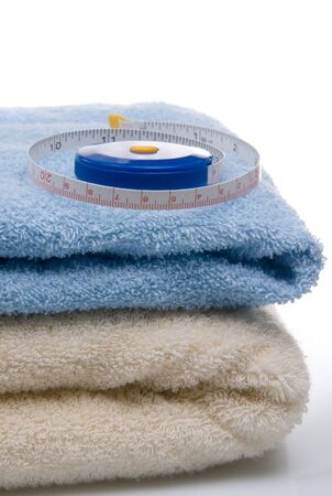 Pile of towels and tape measure, white backgroundの写真素材