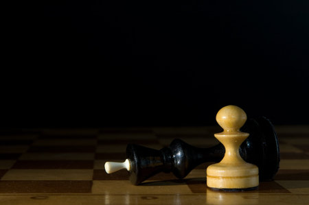 Two chessmen on a chessboard, black backgroundの写真素材