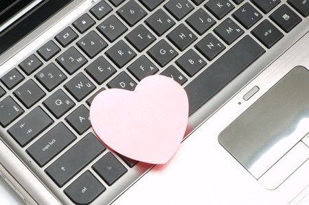 Black laptop keyboard with pink stickerの写真素材