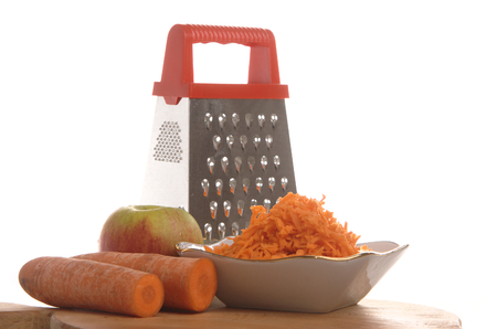 Grated carrots in a cup on a white backgroundの写真素材