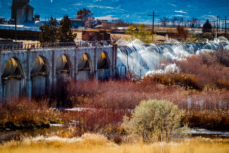 The Bear River Dam in Grace, Idaho has a pipe that transports water from the dam. When the temperatures drop below freezing, the water that leaks from the pipes form cool ice sculptures in nearby brush.の写真素材