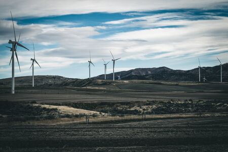 A wind turbine farm canvases the countryside, as cropland does double-duty producing green energy for Idaho.の写真素材