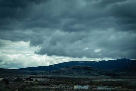 The storm clouds at this high elevation always seem low enough to reach out and touch them, as seen in this photo of evening storm clouds over a rural valley.の写真素材