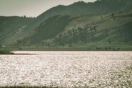 The sparkling water of the Alexander Reservoir meets rolling green hills.の写真素材