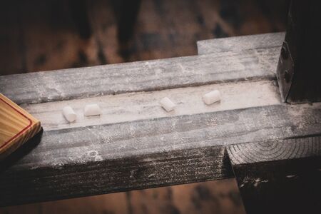 Chalk sits in dust on a vintage wooden chalkboard, with an old eraser in this farmhouse-style scene.の写真素材