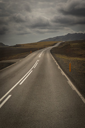 Asphalt road in Iceland with cloudy sky. Toned image.の写真素材