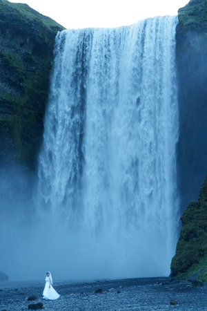 A bride in a wedding dress on the background of a waterfall.の写真素材