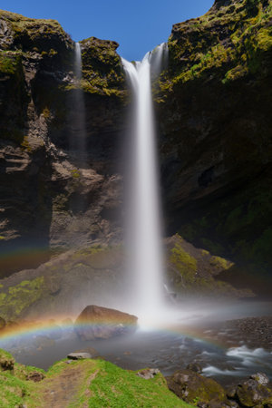 Stunning Rainbow Arcs Over Majestic Icelandic Waterfallの写真素材