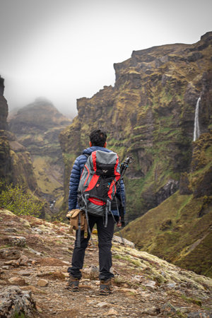 Stunning mountains with cascading waterfalls flowing through the lush MÃºlagljÃºfur Canyon in Iceland's rugged landscapeの写真素材