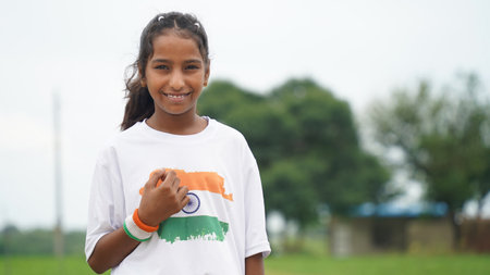 Indian student or children holding or waving Tricolour with greenery in the background, celebrating Independence or Republic day. Har Ghar Tirangaの写真素材