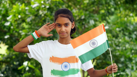 Indian student or children holding or waving Tricolour with greenery in the background, celebrating Independence or Republic day. Har Ghar Tirangaの写真素材