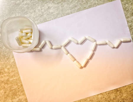 Hyderabad India - March 10, 2021: Assorted pharmaceutical medicine pills, tablets and capsules for the treatment of heart disease. Heart shape and bottle of pills. Copy space for textの写真素材