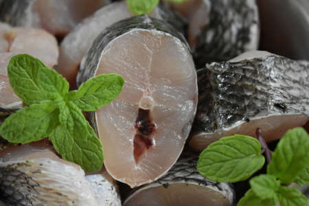 Raw fish fillet of tilapia on a cutting Board with lemon and spices on a steel bowl. cutting board with copy space, india.の写真素材