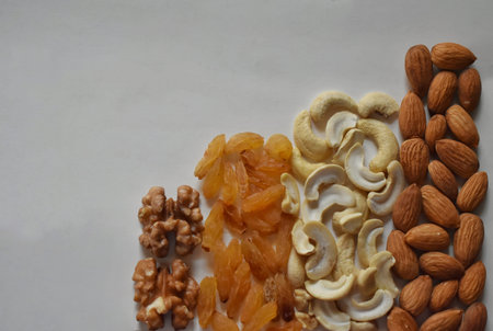Nuts and dried fruits assortment on stone table in a bar shape, top view.