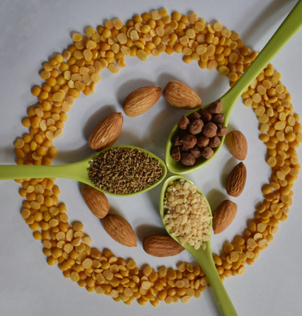 various grain, beans, legumes, peas, lentils and almonds in spoon on the white background
