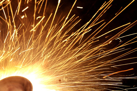 sparks from welding at a construction site as a background.