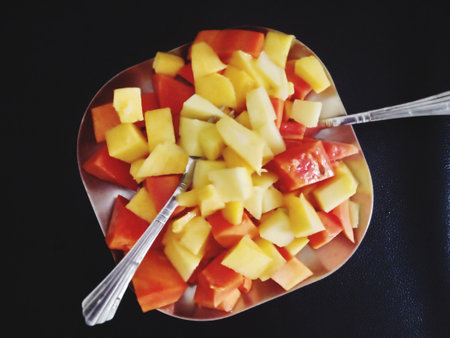 Slices of melon and papaya in a bowl.の写真素材