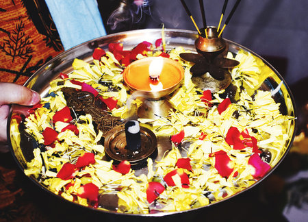 Candle and flower petals in a bowl for diwaliの写真素材