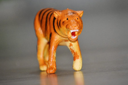 Close-up of a wooden toy tiger on a gray background.