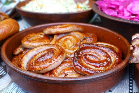 Round fried sausages in a bowl on a table with snacks