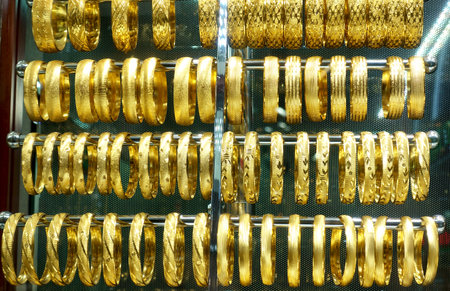 Rows of gold bracelets in the shop window of the jewelry store.