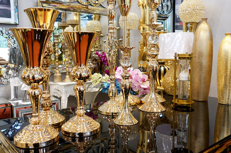 Various golden vases and other decor items on the counter.の写真素材