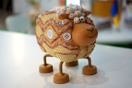 Funny decorative figure of a sheep stands on the table.の写真素材