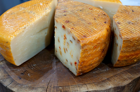 Various pieces of cheese on a wooden table.の写真素材