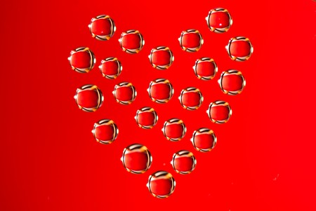 Water drops in the form of heart on a celebratory backgroundの写真素材