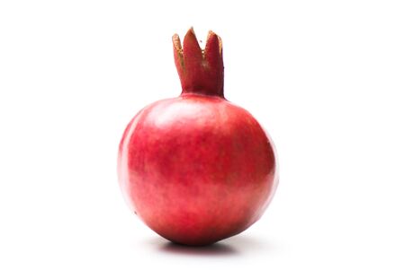 ripe whole pomegranate on the white isolated backgroundの写真素材