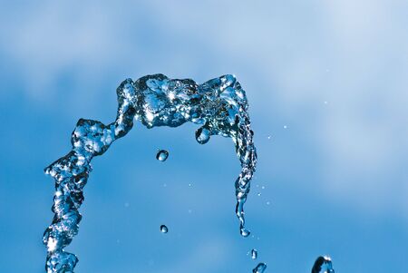 Beautiful splashes of water on a background blue skyの写真素材