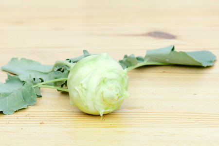 fresh cabbage kohlrabi with leaves on a wooden table
