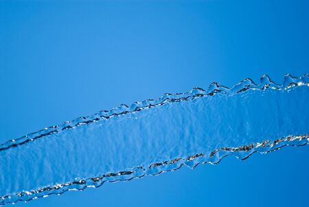 Beautiful splashes of water on a background blue skyの写真素材