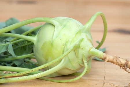 fresh cabbage kohlrabi with leaves on a wooden tableの写真素材