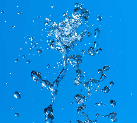 Beautiful splashes of fresh water on a color backgroundの写真素材