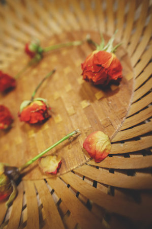 small dried roses in a plate of bamboo, wood. still lifeの写真素材