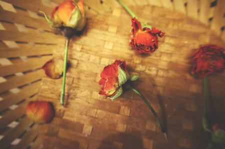 small dried roses in a plate of bamboo, wood. still life