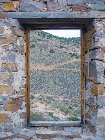 Wooden window frame of a ghost town stone house.