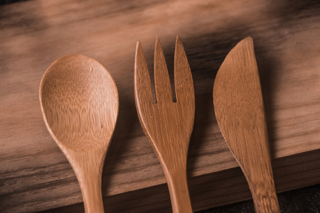 Old wooden cutlery, leaning on old wooden board. texture backgroundの写真素材