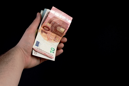 Hand with bills on black backgroundの写真素材