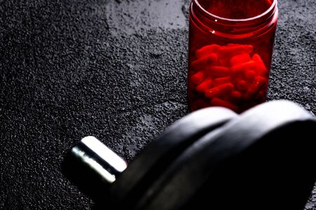 Sports supplements with weights on dark background. Medicinesの写真素材