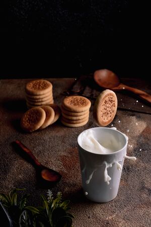 Fresh milk with homemade cookies on a wooden table, dark background.の写真素材