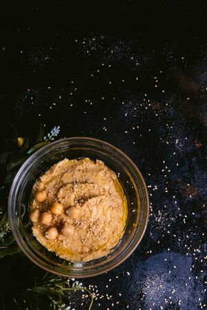 Chickpea hummus with sesame in glass bowl on wooden table. Vegan foodの写真素材
