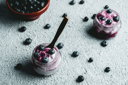 Homemade blueberry yogurt in glass bowls, healthy breakfast, selective focus. background with fresh...