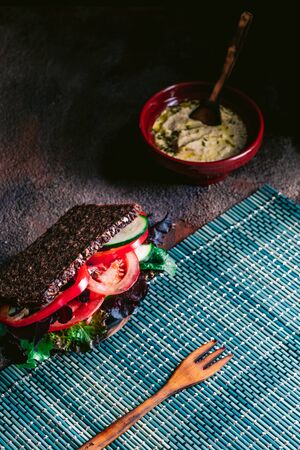 Vegetable sandwich with tomato, lettuce, zucchini, cucumber and more vegetables. Dark background. Vegan foodの写真素材