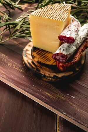 Cured Fuet chorizo, cheese, sausage from Spain. Salami sausage snack. Copy space. Wooden table background.の写真素材